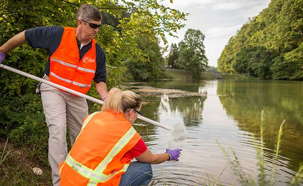 ORISE survey technicians collect a water sample