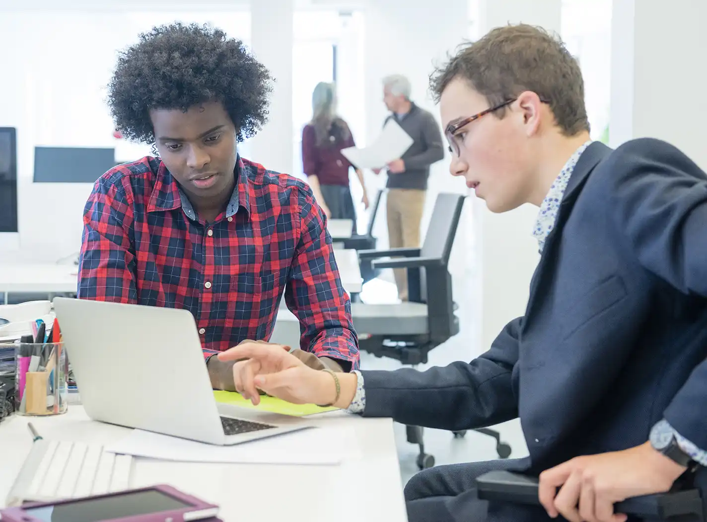 young african male and young white male looking at computer screen