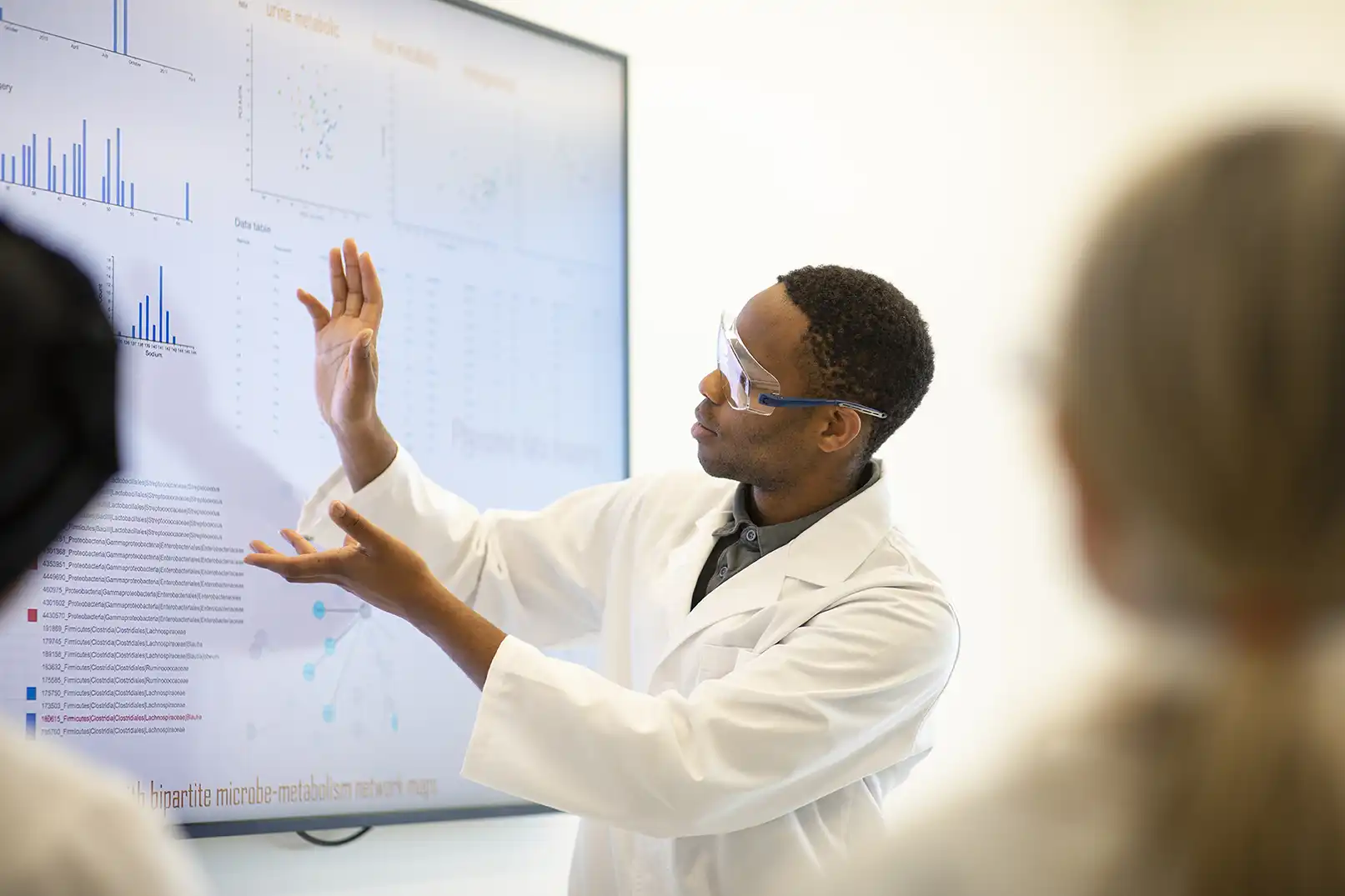 black male pointing at a large screen