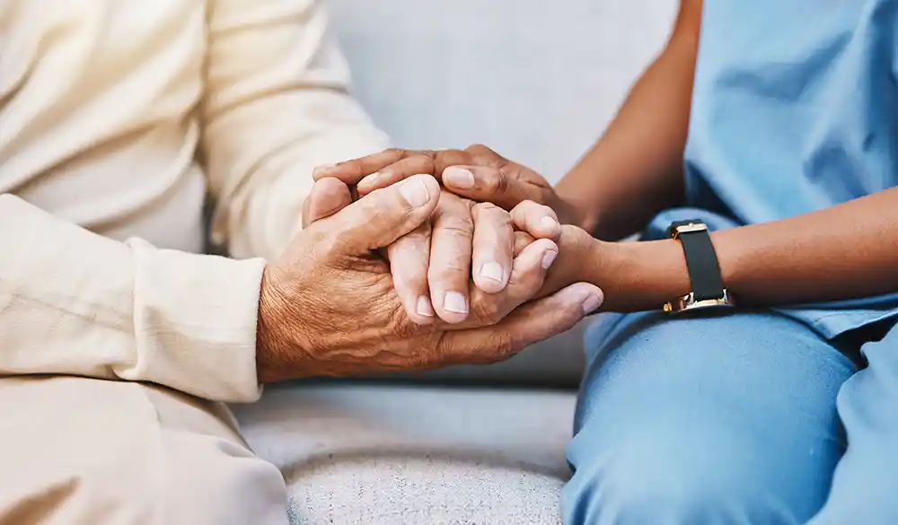 elder person holding hands with younger person