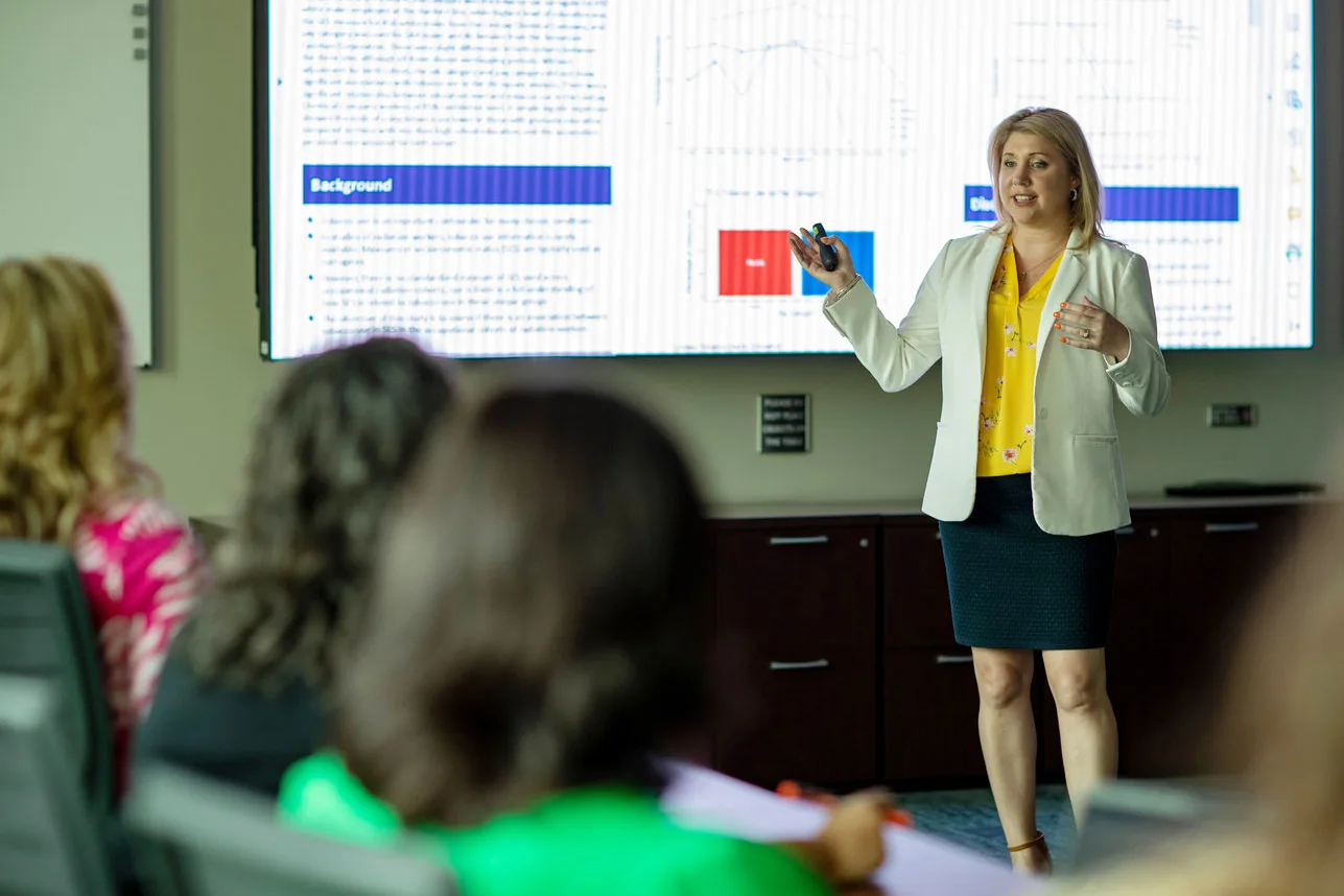 A female epidemiologist give a presentation to a group