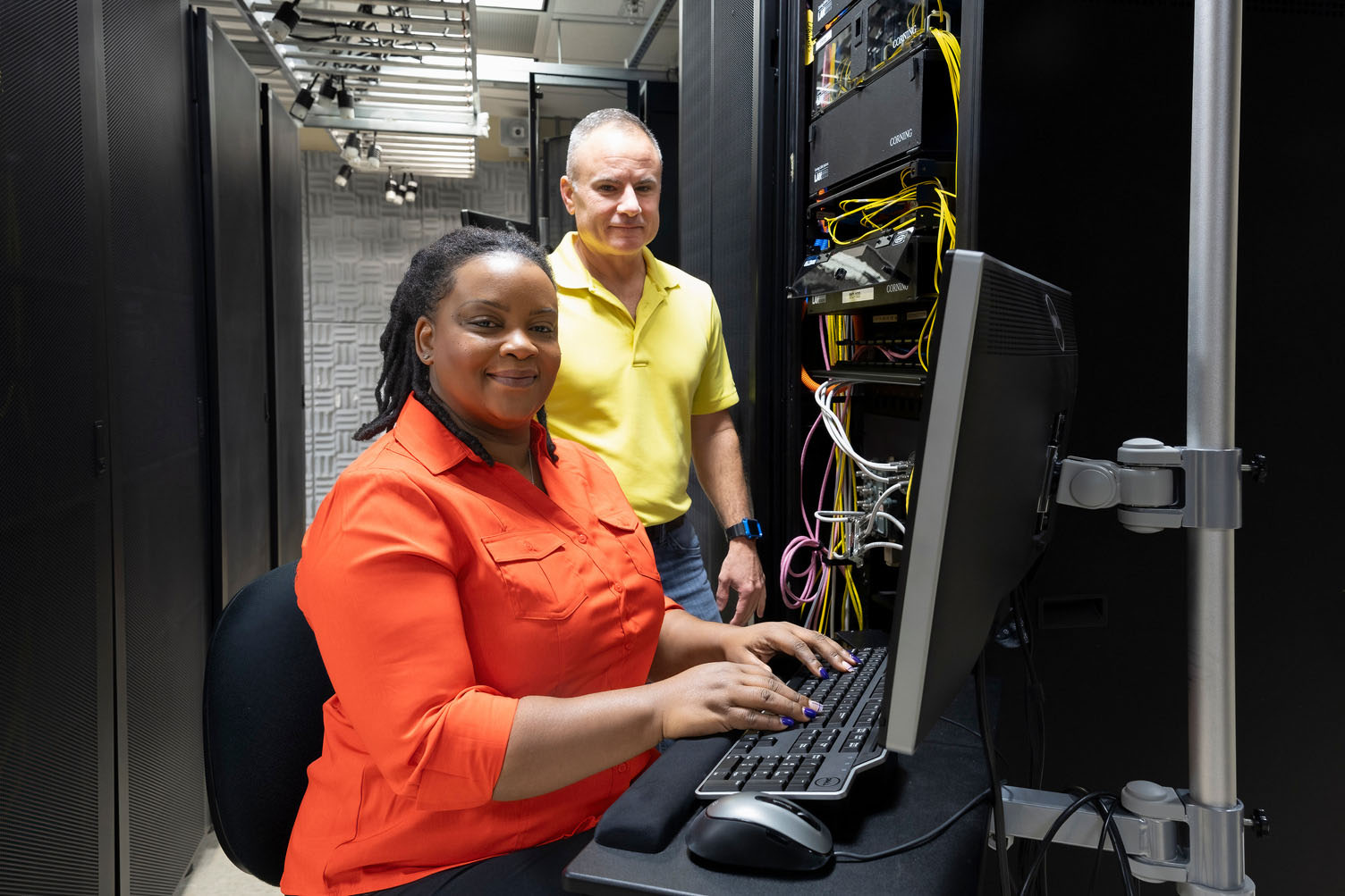 Two male IT experts work together in a server room