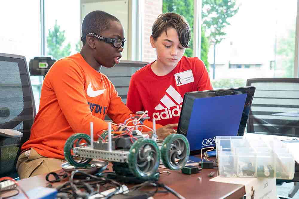 Two male students participate in the CIA Robotics Academy