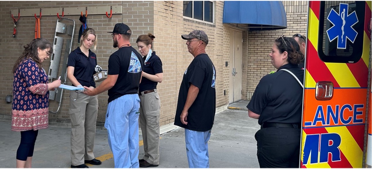 Registered Nurse Kristy Diffenderfer-Stewart (fourth from left) discussed triage and decontamination with the MMC staff while Health Physicist Meghan Dieffenthaller (second from left) surveyed the exercise patients for contamination.