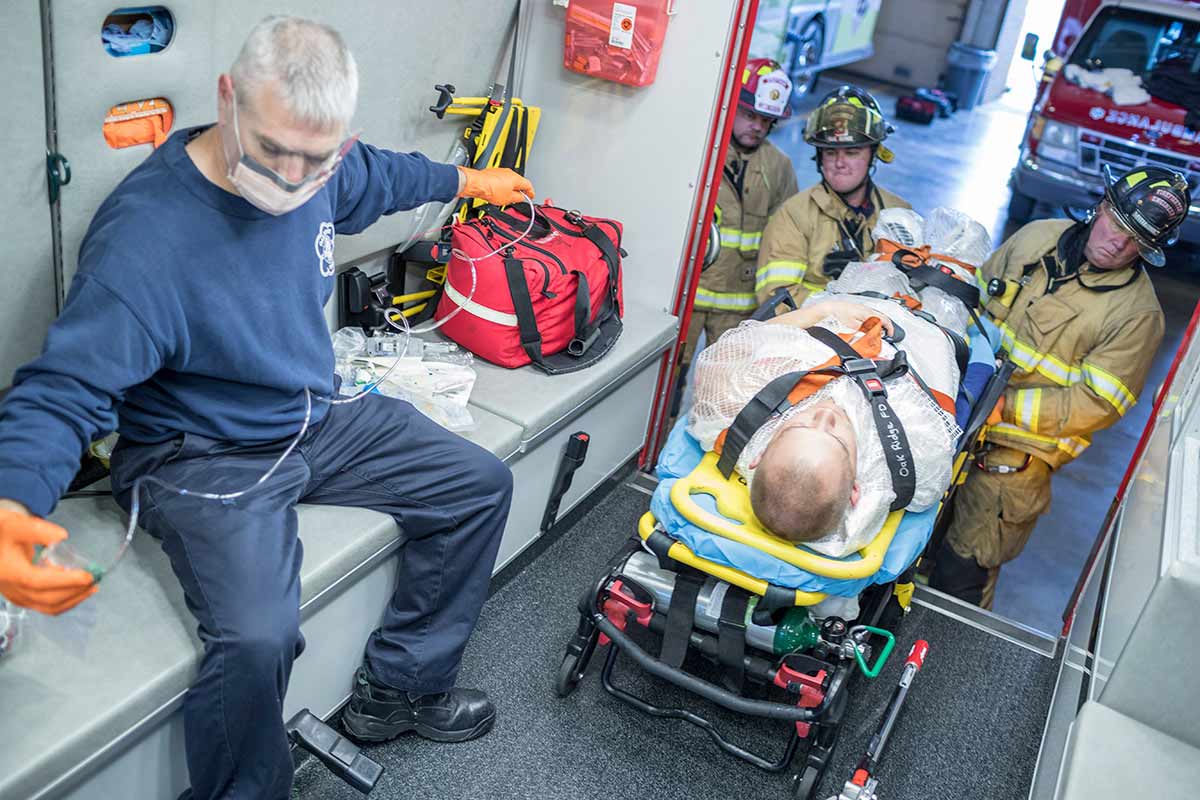 Fire and EMT professionals transport a patient during a REAC/TS continuing medical education course