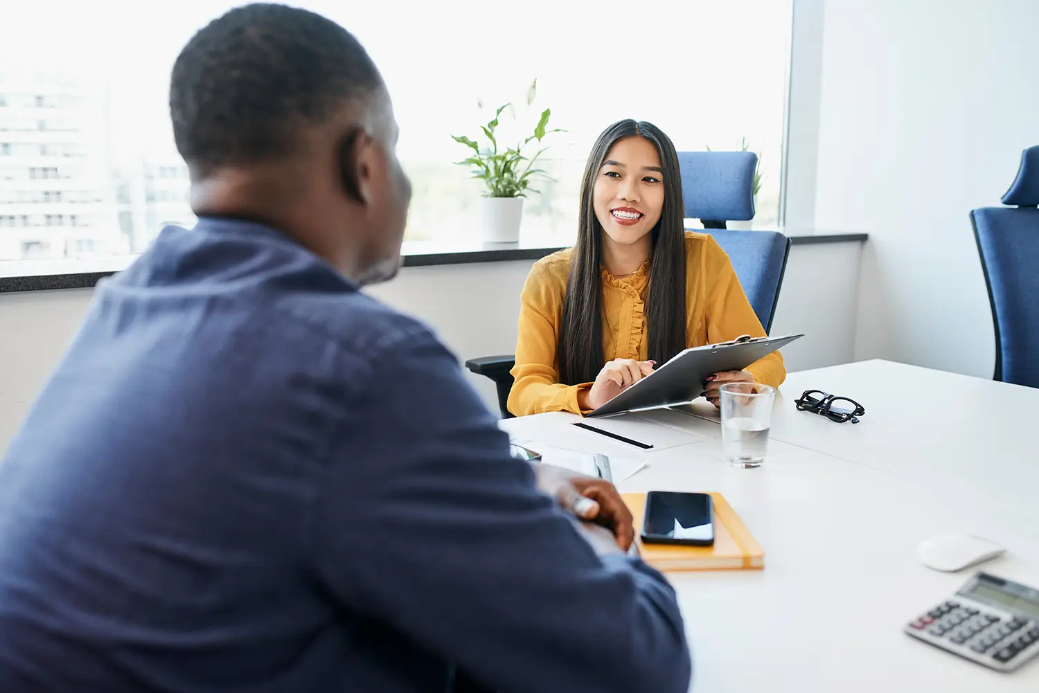 Young woman recruiting employee talking with man during job interview in the office