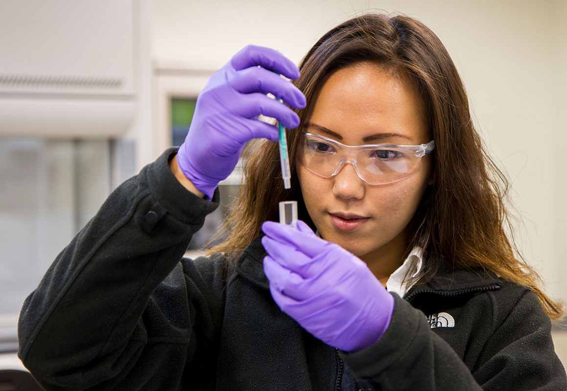 Female undergraduate student conducting research in a laboratory