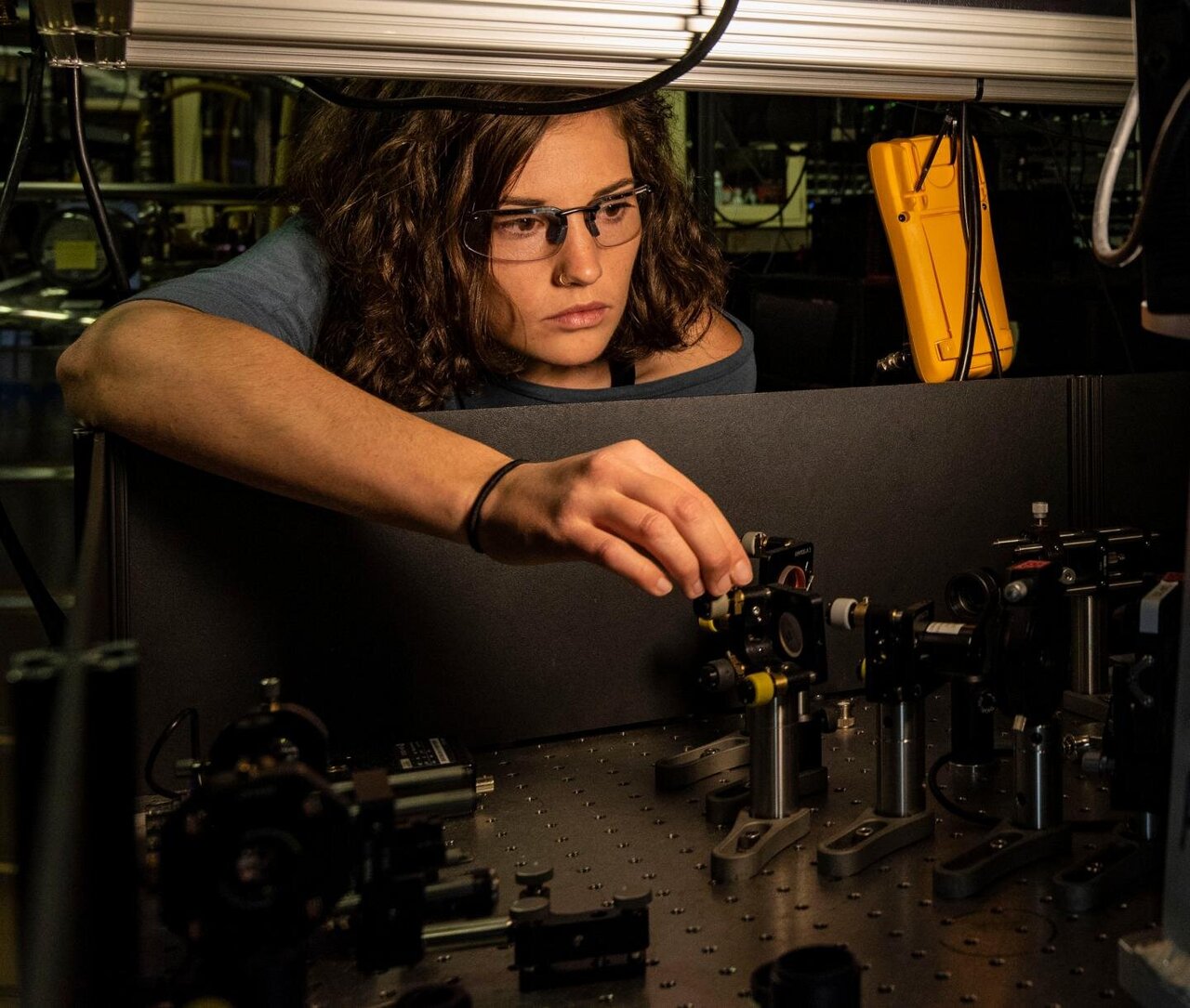 Katherine McCormick, Ph.D., adjusts a mirror to steer a laser beam onto an atom