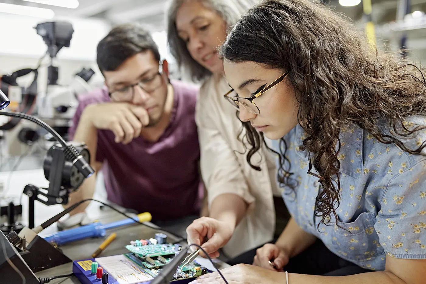 College instructor assisting electrical engineering students