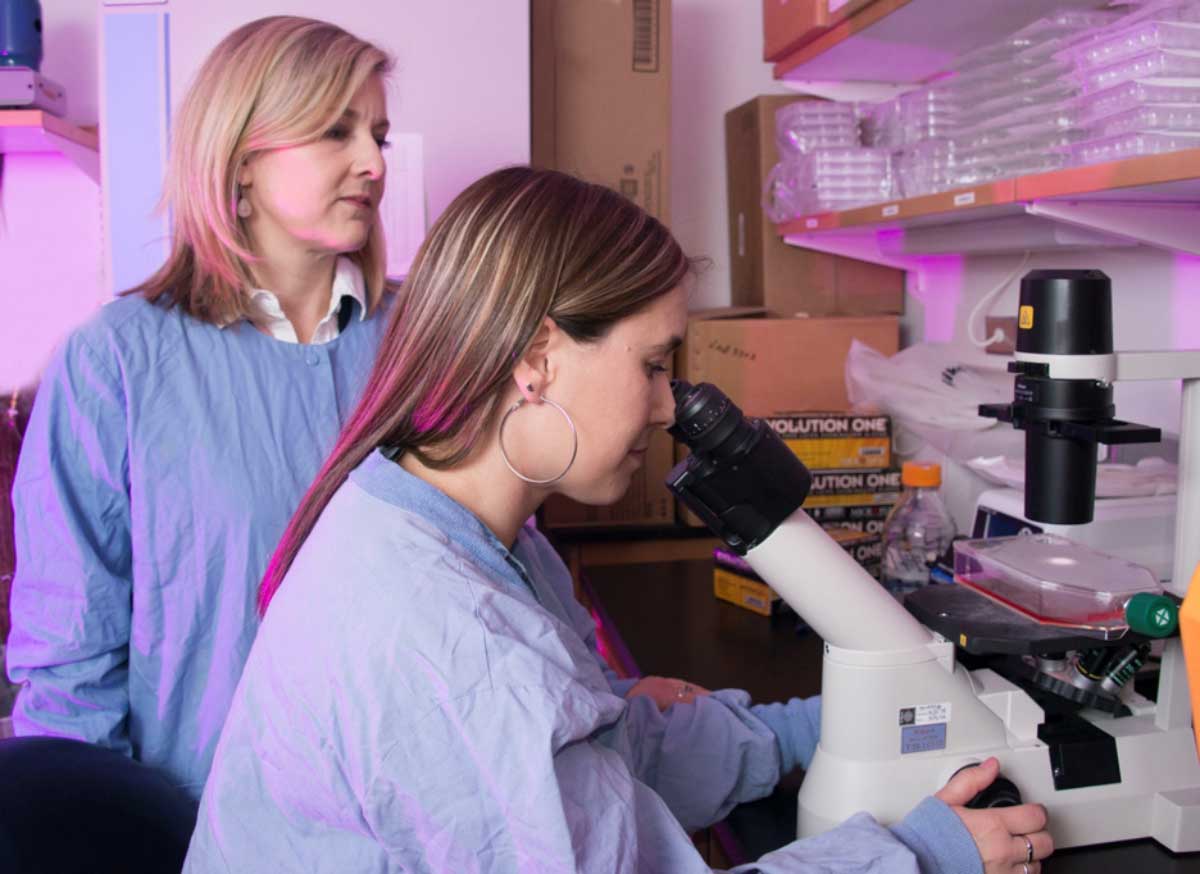 A researcher works with a mentor scientist in a laboratory setting